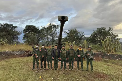 In this photo provided by the Kokang online media, members of an ethnic armed forces group, one of the three militias known as the Three Brotherhood Alliance, pose for a photograph in front of weapons the group allegedly seized from Myanmar's army outpost on a hill in Hsenwi township in Shan state, Myanmar, on Nov. 24, 2023. A major offensive against Myanmar's military-run government by an alliance of three militias of ethnic minorities has been moving at lightning speed, inspiring resistance fo