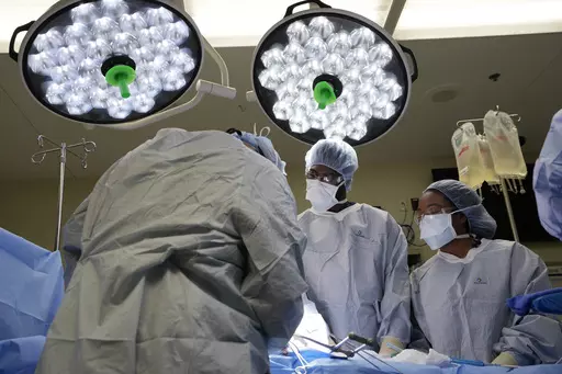 Meharry Medical College students Emmanuel Kotey, center, and Teresa Belledent, right, watch as the liver and kidneys are removed from an organ donor June 15, 2023, in Jackson, Tenn. They’re part of a novel pilot program to encourage more Black and other minority doctors-to-be to get involved in the transplant field, increasing the trust of patients of color. (AP Photo/Mark Humphrey)