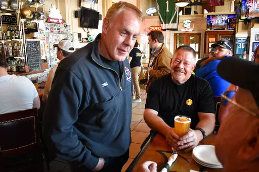 Montana U.S. House candidate and former Secretary of Interior Ryan Zinke, left, speaks with patrons at Metals Sports Bar and Grill, May 13, 2022, in Butte, Mont. Zinke is seeking election to a newly created U.S. House district. (AP Photo/Matthew Brown, File)