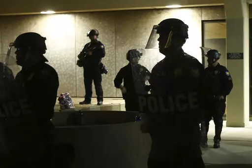 Phoenix Police stand in front of police headquarters on May 30, 2020, in Phoenix, waiting for protesters marching to protest the death of George Floyd. A controversial Arizona law restricting how the public can film police is facing its first legal challenge with a lawsuit filed by the ACLU. The group's Arizona chapter, joined by several Arizona news organizations, filed a petition Tuesday, Aug. 23, 2022, in federal court to stop the law. (AP Photo/Ross D. Franklin, File)