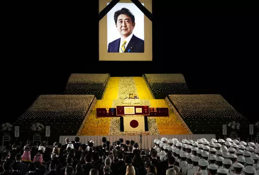 A portrait of former Japanese Prime Minister Shinzo Abe hangs on the stage during his state funeral, Tuesday, Sept. 27, 2022, Tokyo. Abe was assassinated in July. (Franck Robichon/Pool Photo via AP)