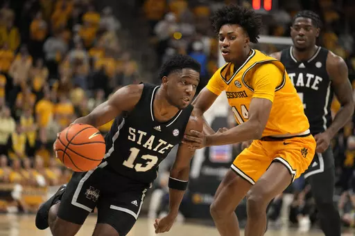 Mississippi State's Josh Hubbard (13) heads to the basket past Missouri's Anthony Robinson II (14) during the first half of an NCAA college basketball game Saturday, Feb. 10, 2024, in Columbia, Mo. (AP Photo/Jeff Roberson)
