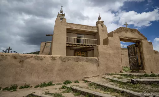 An exterior view of the San Jose de Gracia Catholic Church, built in 1760, in Las Trampas, New Mexico, Friday, April 14, 2023. Threatened by depopulation, dwindling congregations and fading traditions, some faithful are fighting to save their historic adobe churches and the uniquely New Mexican way of life they represent. (AP Photo/Roberto E. Rosales)