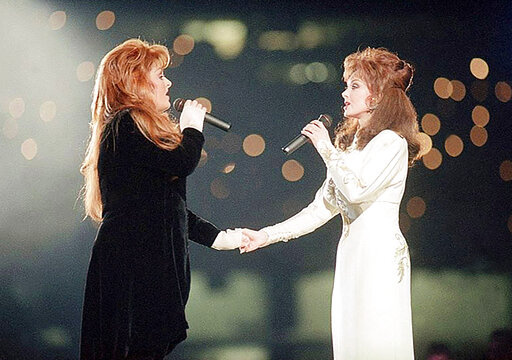 Wynonna Judd, left, and her mother, Naomi Judd, of The Judds, perform during the halftime show at Super Bowl XXVIII in Atlanta on Jan. 30, 1994. Naomi Judd, the Kentucky-born matriarch of the Grammy-winning duo The Judds and mother of Wynonna and Ashley Judd, has died, her family announced Saturday, April 30, 2022. She was 76. (AP Photo/Eric Draper, File)