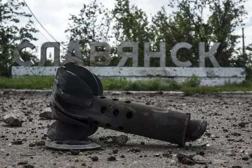 A part of the mortar shell is seen in front of a sign that reads 'Slovyansk', after heavy fighting between pro-Russian fighters and Ukrainian government troops just outside Slovyansk, eastern Ukraine, Wednesday, July 9, 2014. The eastern Ukrainian city of Slovyansk was occupied by pro-Russian separatists for months in 2014. Now its people are preparing to defend their community again as the fighting draws closer and invites a major battle. Slovyansk is a city of splintered loyalties, with some r