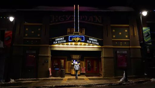 A pedestrian peers into the ticket booth of the Egyptian Theatre before the start of the 2023 Sundance Film Festival, Wednesday, Jan. 18, 2023, in Park City, Utah. The annual independent film festival runs from Jan. 19-29. (AP Photo/Chris Pizzello)