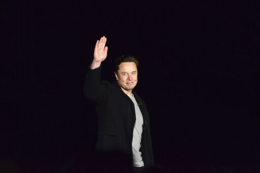 Elon Musk waves while providing an update on SpaceX's Starship, Thursday, Feb. 10, 2022, near Brownsville, Texas. In April 2022, a group of Tesla shareholders suing Musk over some 2018 tweets about taking the company private is asking a federal judge to order him to stop commenting on the case. (Miguel Roberts/The Brownsville Herald via AP, File)