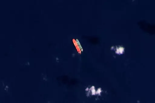 In this satellite photo provided by Planet Labs PBC, vessels identified as the Virgo, left, and the Suez Rajan, by the advocacy group United Against Nuclear Iran, are seen in the South China Sea on Feb. 13, 2022. A Greek shipper has pleaded guilty to a charge over it smuggling sanctioned Iranian crude oil and agreed to pay a $2.4 million fine, U.S. federal court papers seen Thursday, Sept. 7, 2023 by The Associated Press show. (Planet Labs PBC via AP, File)