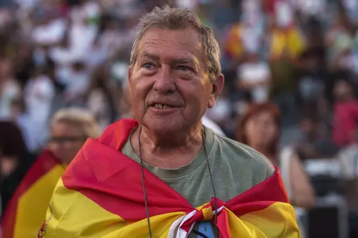 A supporter of VOX far right party wrapped in a Spanish flag attends an election campaign event in Guadalajara, Spain, Saturday, July 15, 2023. Spain's general election Sunday, July 23 could make the country the latest European Union member to shift to the political right. Most polls put the right-wing Popular Party ahead of the Socialists but likely needing the support of the extreme right Vox party to form a government. (AP Photo/Manu Fernandez)