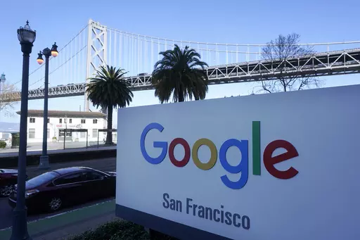 The San Francisco-Oakland Bay Bridge is seen behind a Google sign at the company's office in San Francisco, April 12, 2023. Lawyers for both the Department of Justice and Google are presenting closing arguments in Washington, D.C., Friday, May 3, 2024, to conclude the biggest antitrust case in a quarter century. (AP Photo/Jeff Chiu, File )