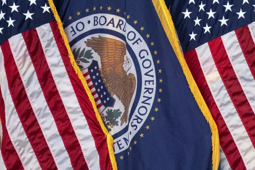 The flag of the Federal Reserve hangs between American flags at a news conference following a Federal Open Market Committee meeting on July 26, 2023 in Washington. On Wednesday, the Federal Reserve releases minutes from the July meeting when it raised its benchmark borrowing rate by another quarter point to 5.4%, the highest level in 22 years. (AP Photo/Nathan Howard, File)