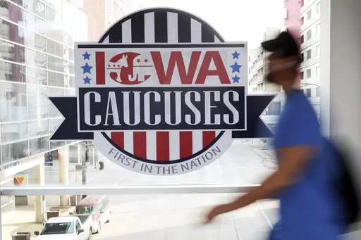 A pedestrian walks past a sign for the Iowa Caucuses on a downtown skywalk, in Des Moines, Iowa, on Feb. 4, 2020. Iowa Republicans have scheduled the party’s presidential nominating caucuses for Jan. 15, 2024, putting the first votes of the next election a little more than six months away. (AP Photo/Charlie Neibergall, File)