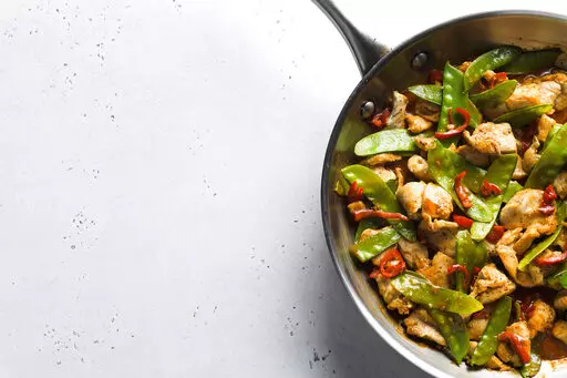 This image released by Milk Street shows a recipe for stir-fried chicken and snow peas. This recipe, with just six ingredients, was inspired by the popular Malaysian dish ayam paprik.  (Milk Street via AP)