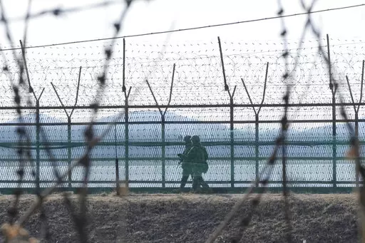 South Korean army soldiers patrol along the barbed-wire fence in Paju, South Korea, near the border with North Korea, Thursday, Feb. 16, 2023. South Korea called North Korea "our enemy" in its biennial defense document published Thursday, reviving the label for its rival for the first time in six years, as tensions worsen between the two. (AP Photo/Ahn Young-joon)