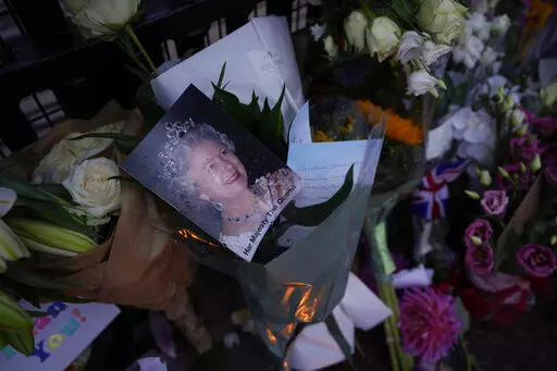 Messages, flowers and candles are seen at the gates of Buckingham Palace in London, Friday, Sept. 9, 2022. (AP Photo/Kirsty Wigglesworth)