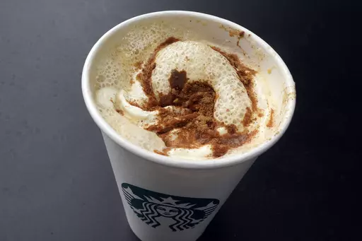 A Pumpkin Spice Latte drink rests on a table at a Starbucks in New York, Thursday, Aug. 24, 2023. The seasonal drink that made pumpkin spice a star is marking two decades in the world. (AP Photo/Richard Drew)