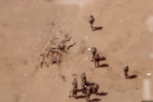 This image taken from a video shows soldiers burying bodies near an army base in northern Mali. The French military says it has videos of Russian mercenaries burying bodies near an army base in northern Mali which it says is part of a smear campaign against the French who handed control of the base to Malian forces earlier this week. Aerial surveillance taken by the French military early Thursday and provided to The Associated Press show what appear to be 10 Caucasian soldiers covering approxima