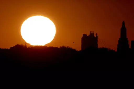 The sun sets beyond the downtown skyline of Kansas City, Mo., as the autumnal equinox marks the first day of fall Sunday, Sept. 22, 2013. During the equinox, the Earth’s axis and its orbit line up so that both hemispheres get an equal amount of sunlight. (AP Photo/Charlie Riedel, File)