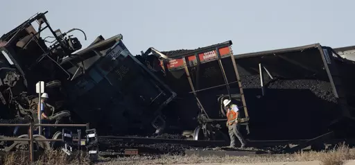 Workers toil to clear rail cars that derailed and collapsed a bridge over Interstate 25 northbound, Monday, Oct. 16, 2023, north of Pueblo, Colo. Federal investigators said Thursday they’re looking at BNSF Railway’s inspection and maintenance practices as the investigate the accident that killed a truck driver passing beneath the train. (AP Photo/David Zalubowski, File)