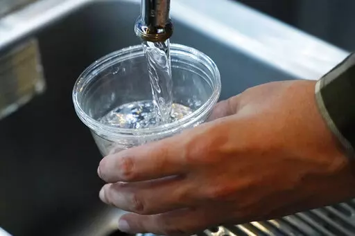 A cup of water is drawn from a faucet at Johnny T's Bistro and Blues, a midtown Jackson, Miss., restaurant and entertainment venue on Sept. 1, 2022. The beleaguered water system in Mississippi's capital city disrupted daily life for 150,000 residents for several days, but Jackson's water is now safe to drink according to the Environmental Protection Agency on Monday, Oct. 31, 2022. (AP Photo/Rogelio V. Solis, File)