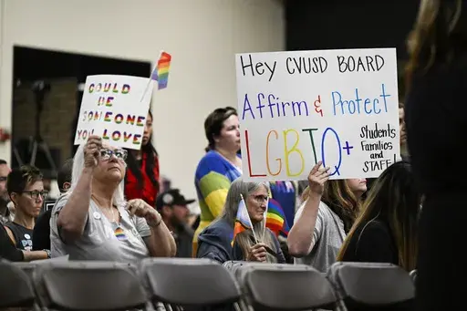 Parents, students, and staff of Chino Valley Unified School District hold up signs in favor of protecting LGBTQ+ policies at Don Antonio Lugo High School, June 15, 2023, in Chino, Calif. Californians won't be voting this November on a policy that would have required schools to notify parents if their child asks to change their gender identification. Proponents of a ballot measure to create such a statewide policy announced Tuesday, May 28, 2024, that they failed to collect enough signatures to p