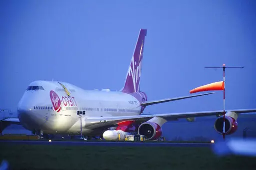 Virgin Atlantic Cosmic Girl, a repurposed Virgin Atlantic Boeing 747 aircraft carrying a rocket, is parked at Spaceport Cornwall, at Cornwall Airport in Newquay, England, Monday, Jan. 9, 2023. Engineers are making final preparations for the first satellite launch from the U.K. later Monday, when a repurposed passenger plane is expected to release a Virgin Orbit rocket carrying several small satellites into space. (Ben Birchall/PA via AP)