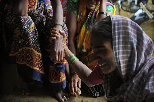 A woman holds the hand of her relative as family members of people trapped under rubble wail after a landslide washed away houses in Raigad district, western Maharashtra state, India, July 20, 2023. The devastation of this year's monsoon season in India, which runs from June to September, has been significant. (AP Photo/Rafiq Maqbool)