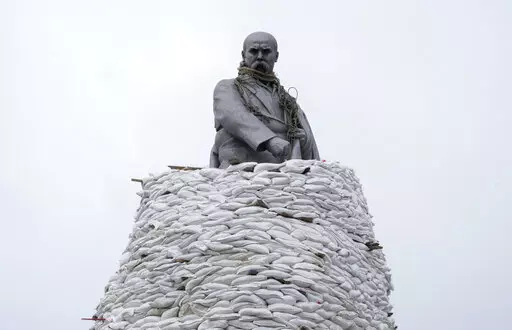 A monument of Taras Shevchenko, a Ukrainian poet and a national symbol, is covered with bags to protect it from Russian shelling in Kharkiv, Ukraine, Sunday, March 27, 2022. The bronze, 16-meter high monument was placed in 1935, survived WWII and is considered one of the world's best monuments to Shevchenko. (AP Photo/Efrem Lukatsky)