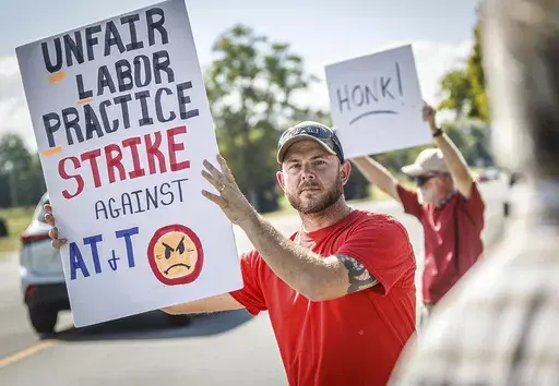 Drew Thigpen, left, and Robert Rogers join other AT&T workers from the CWA Local 3911 as they picket outside an AT&T warehouse on Cox Boulevard in Sheffield, Ala., on Monday, Aug. 19, 2024. (Dan Busey/The TimesDaily via AP)