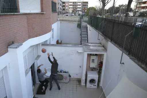 Hasan Zaheda plays basketball with his son Riad in the courtyard of their house in Rome, Sunday, March 2, 2025. (AP Photo/Alessandra Tarantino)