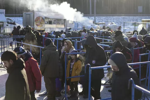 Migrants queue to receive hot food at a logistics center at the checkpoint logistics center "Bruzgi" at the Belarus-Poland border near Grodno, Belarus, on Dec. 22, 2021. Poland’s conservative governing party was hoping to make migration a key campaign theme ahead of the country’s national election. But not like this. The Law and Justice party is being rocked by reports that Polish consulates issued visas in Africa and Asia in exchange for bribes, opening the door for migrants to enter the Eu