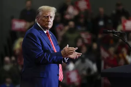 Republican presidential candidate former President Donald Trump stands on stage after speaking during a commit to caucus rally, Saturday, Jan. 6, 2024, in Clinton, Iowa. (AP Photo/Charlie Neibergall)