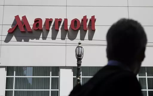 A person walks past the San Francisco Marriott Union Square hotel on July 11, 2019, in San Francisco. Multinational companies including Amazon, Marriott and Hilton pledged Monday June 19, 2023 to hire more than 13,000 refugees, including Ukrainian women who have fled the war with Russia, over the next three years in Europe. (AP Photo/Jeff Chiu, File)