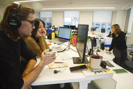 John D'Amico, deputy executive editor for The News Movement (TNM), a social media news operation re-imagined for Gen-Z consumers, left, reviews video with reporter Kimberly Avalos, Wednesday, March 1, 2023, in New York. TNM uses a staff of reporters with an average age of 25 to make tailored news content for sites like TikTok, Instagram, YouTube and Twitter. (AP Photo/Bebeto Matthews)