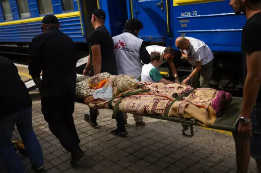 An elderly patient is carried in a stretcher to board a medical evacuation train run by MSF (Doctors Without Borders) at the train station in Pokrovsk, eastern Ukraine, eastern Ukraine, Sunday, May 29, 2022. In wheelchairs and on stretchers, in ambulances and on the station platform, they wait. Medical staff pull out ramps and wheel the patients onto the specially equipped train that will carry them westwards, away from the fighting raging in eastern Ukraine. (AP Photo/Francisco Seco)
