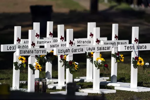 Crosses with the names of Tuesday's shooting victims are placed outside Robb Elementary School in Uvalde, Texas, Thursday, May 26, 2022. The 18-year-old man who slaughtered 19 children and two teachers in Texas left a digital trail that hinted at what was to come.  (AP Photo/Jae C. Hong)