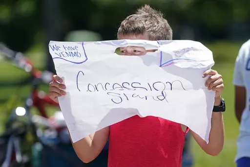 Andrew Addison holds up a sign advertising that he takes Venmo for payment at his corner drink stand, Monday, May 30, 2022, in Nolensville, Tenn. Venmo will officially allow teenagers to open an account with their parents' permission, the company said Monday, expanding the popular social payments app to a demographic that is likely to embrace it almost immediately. (AP Photo/Mark Humphrey, File)