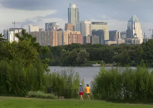 Women walk through the Lakeshore area of Austin, Texas, with the skyline in the background on Aug. 31, 2016. The Texas capital became the largest U.S. city to challenge its 2020 census figures by filing an appeal with the Census Bureau in May 2022, saying that it has more than the 961,855 residents counted during the nation's once-a-decade head count. (Ralph Barrera/Austin American-Statesman via AP, File)