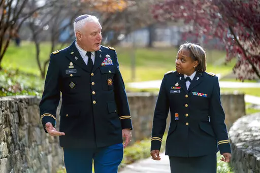 Head National Guard chaplain Col. Larry Bazer, deputy director of the chaplain office, left, and Chaplain Maj. A'Shellarien Lang, right, speak at the National Guard Bureau in Arlington, Va., Friday, Dec. 17, 2021. (AP Photo/Andrew Harnik)