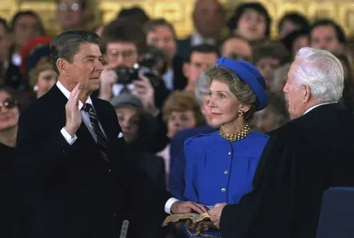 First lady Nancy Reagan, center, looks on as President Ronald Reagan is sworn in during ceremonies in the Rotunda beneath the Capitol Dome in Washington, Jan. 21, 1985. (AP Photo/Ron Edmonds, File)