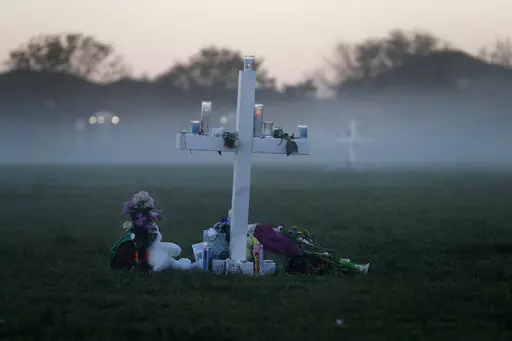In this Feb. 17, 2018, file photo, an early morning fog rises where 17 memorial crosses were placed for the 17 students and faculty killed in the shooting at Marjory Stoneman Douglas High School in Parkland, Fla. The 12 jurors and 10 alternates chosen this past week to decide whether Cruz is executed will be exposed to horrific images and emotional testimony, but must deal with any mental anguish alone. (AP Photo/Gerald Herbert, File)
