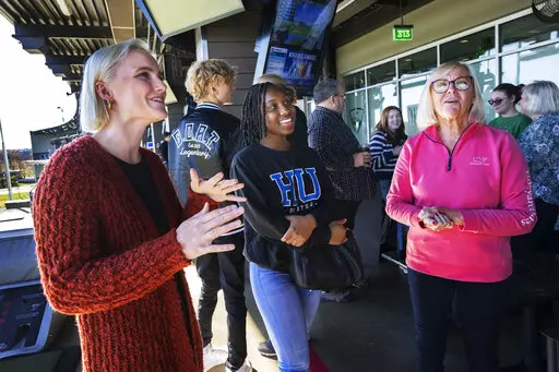 CIA Officers Memorial Foundation staff members Calista Anderson, left, and Nancy Faucette, right, talk with students during a gathering for the current foundation scholarship recipients, Saturday, Nov. 26, 2022, in Ashburn, Va. The foundation recently hired Anderson, the daughter of one of seven officers to die in a December 2009 attack on the CIA's base in Khost, Afghanistan. Anderson wants to help other children of fallen officers and shares her memories of her mother, Jennifer Matthews. (AP P