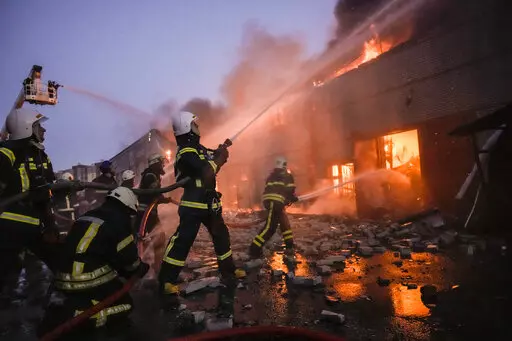 Ukrainian firefighters extinguish a blaze at a warehouse after a bombing in Kyiv, Ukraine, Thursday, March 17, 2022. Russian forces destroyed a theater in Mariupol where hundreds of people were sheltering Wednesday and rained fire on other cities, Ukrainian authorities said, even as the two sides projected optimism over efforts to negotiate an end to the fighting. (AP Photo/Vadim Ghirda)