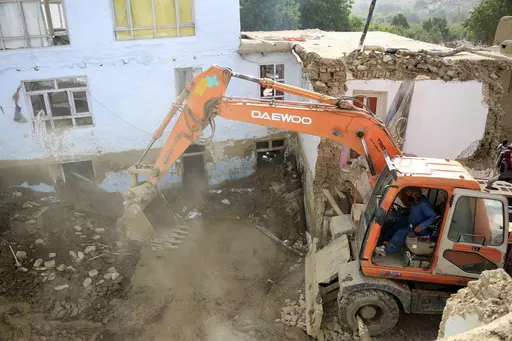 An excavator removes mud from a damaged house after heavy flooding in the Maidan Wardak province in the central of Afghanistan, Sunday, July 23, 2023. Heavy flooding from seasonal rains in Afghanistan killed multiple people and left dozens missing over the past three days. (AP Photo)