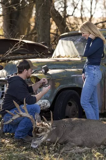 Cole Bures proposes to Samantha Camenzind during a photo shoot after she shot and killed a giant buck during a deer hunt on Nov. 12 , 2023 near Filley, Neb.. Bures surprised his future bride by popping the question after she bagged the deer. (Brenton Lammers/Lammers Media via AP)