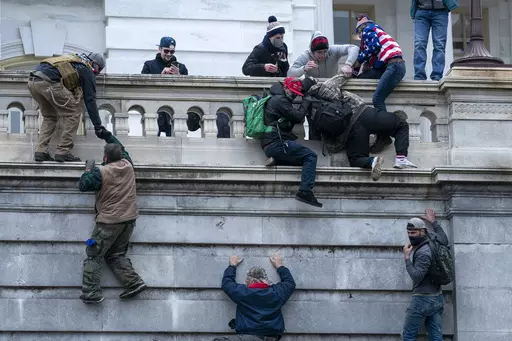 Rioters loyal to President Donald Trump climb the west wall of the the U.S. Capitol, Jan. 6, 2021, in Washington. (AP Photo/Jose Luis Magana, File)