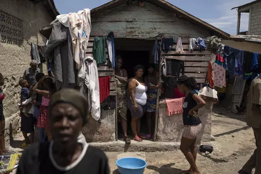 People displaced by gang violence stand in Jean-Kere Almicar's front yard, where they have sought refuge, in Port-au-Prince, Haiti, Sunday, June 4, 2023. Nearly 200 people who once lived in the Cite Soleil slum near Almicar’s house are now camped out in his front yard and nearby areas. They are among the nearly 165,000 Haitians who have fled their homes amid a surge in gang violence. (AP Photo/Ariana Cubillos)