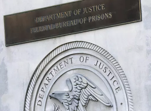 A sign for the Department of Justice Federal Bureau of Prisons is displayed at the Metropolitan Detention Center in the Brooklyn borough of New York,  July 6, 2020. The Justice Department has settled a long-running lawsuit filed by a group of men rounded up in the weeks after the September 2001 attack who say they were abused in a federal lockup in New York City. (AP Photo/Mark Lennihan, File)