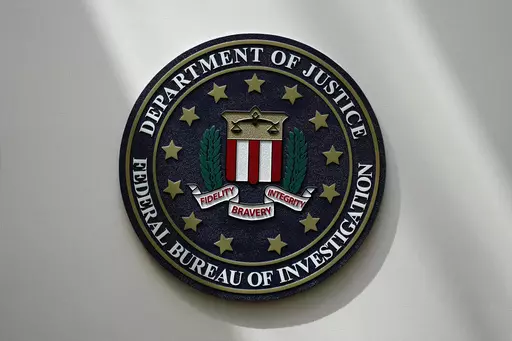 An FBI seal is seen on a wall on Aug. 10, 2022, in Omaha, Neb. The FBI says scammers stole more than $3.4 billion from older Americans last year. An FBI report released Tuesday shows a rise in losses through increasingly sophisticated tactics to trick the vulnerable into giving up their life savings. (AP Photo/Charlie Neibergall, File)