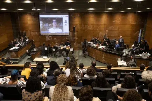 Advisor to slain city councilwoman Marielle Franco, Fernanda Goncalves Chaves, pictured on screen, testifies during the trial of Franco's suspected murderers, at the Court of Justice in Rio de Janeiro, Wednesday, Oct. 30, 2024. (AP Photo/Bruna Prado)